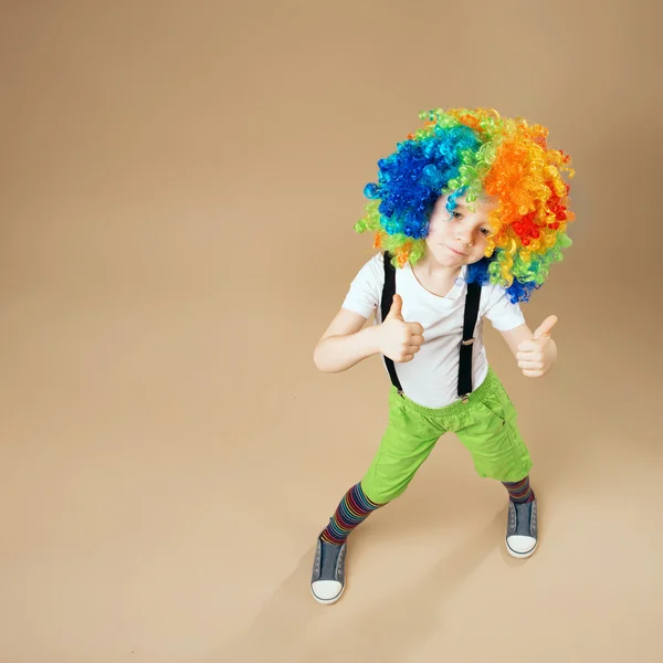 Niño payaso feliz con gran peluca colorida . —  Fotos de Stock