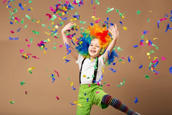 Liten pojke i clown peruk hoppa och ha roligt firar födelse Royaltyfria Stockfoton
