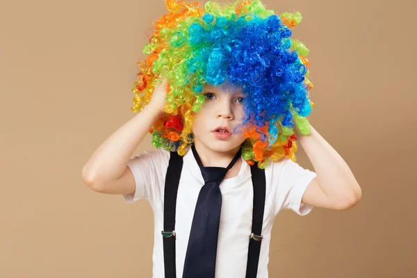 Niño en peluca de payaso oliendo y divirtiéndose —  Fotos de Stock