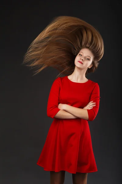 Portrait of a smiling young beautiful girl in a red dress with a — Stock Photo, Image