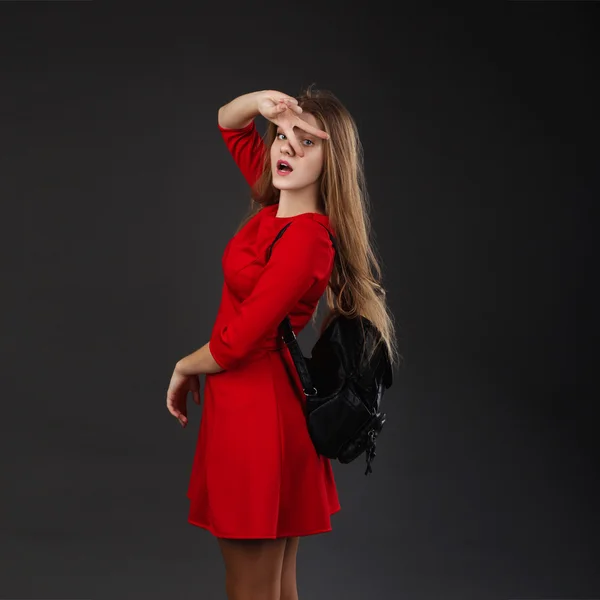 Ritratto di ragazza in abito rosso con zaino in pelle nera — Foto Stock