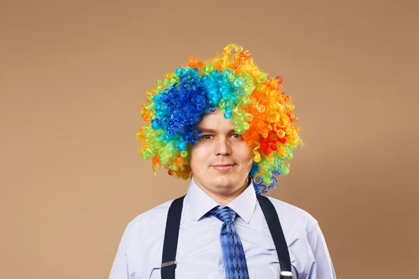 Uomo d'affari sorridente con grande parrucca colorata — Foto Stock