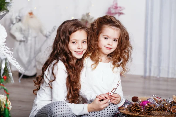 Kleine meisjes in comfortabele huis kleding, zittend op de vloer in bea — Stockfoto