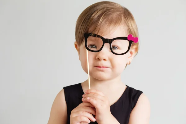 Porträt eines hübschen kleinen Mädchens mit lustigen Papierbrillen — Stockfoto