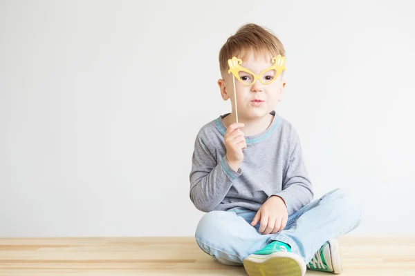 Portrait of a happy little kid with yellow paper glasses — Stock Photo, Image