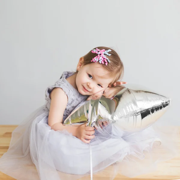 Bébé fille jouer avec argent étoile en forme de ballon . — Photo