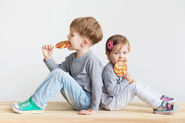 小さな子どもたちがキャンディーを食べて — ストック写真