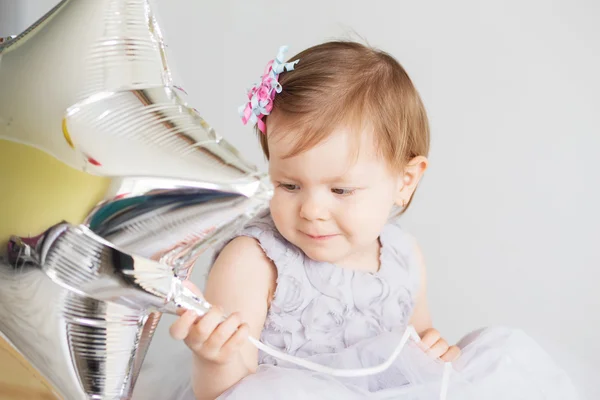 Porträt eines hübschen kleinen Mädchens mit silberner sternförmiger Kugel — Stockfoto