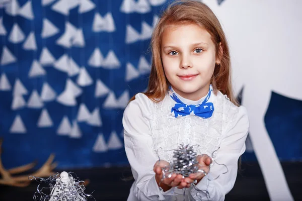 Niña con pajarita en decoraciones navideñas . —  Fotos de Stock