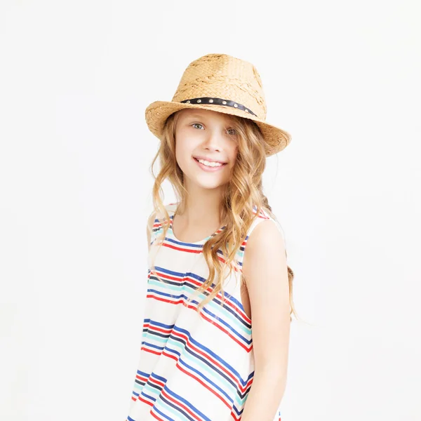 Encantadora niña con sombrero de paja sobre un fondo blanco . — Foto de Stock