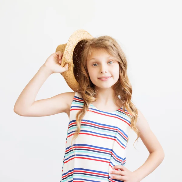 Preciosa niña con sombrero de paja y vestido a rayas sobre un fondo blanco. Niños felices — Foto de Stock