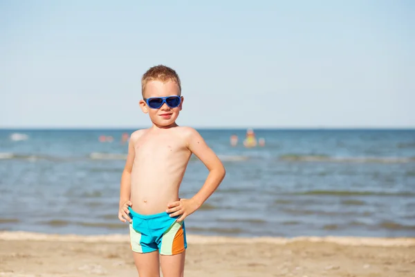 Малыш в очках на пляже — стоковое фото