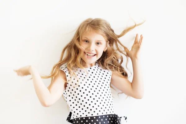 Linda menina brincalhão em um vestido de bolinhas contra um b branco — Fotografia de Stock