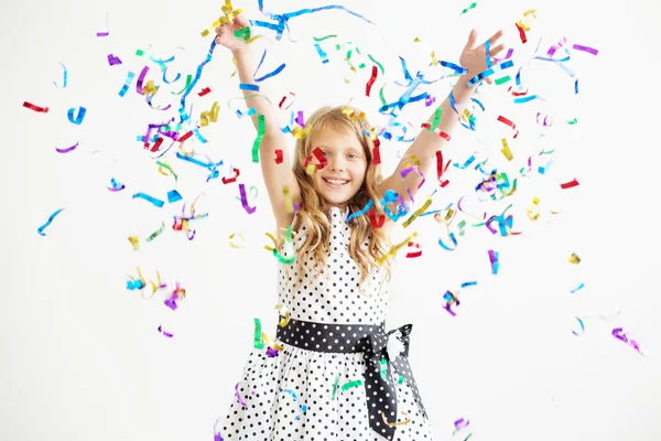 Portrait of a child throws up multi-colored tinsel and confetti