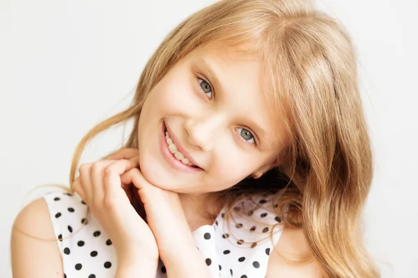 Retrato de cerca de una encantadora niña frente al blanco — Foto de Stock