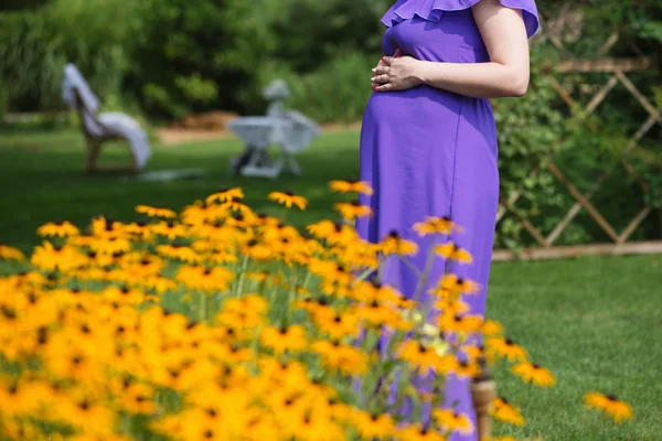 Kobieta w ciąży trzymając ręce na jej baby bump. — Zdjęcie stockowe