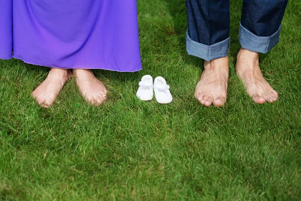 Jovem grávida casal pés descalços no verde gras — Fotografia de Stock