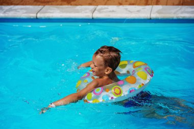 Yüzme Havuzu mavi suda oynayan mutlu çocuk.