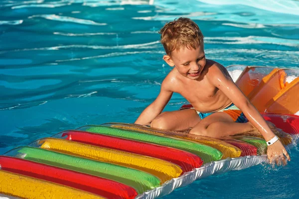 Rapaz bonito nadando na água da piscina . — Fotografia de Stock