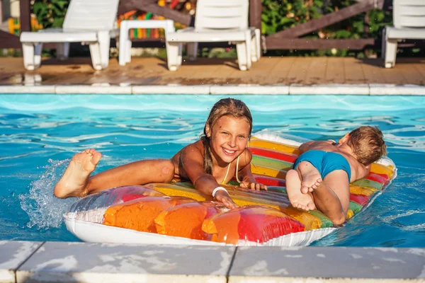 Niños felices jugando en agua azul de la piscina . —  Fotos de Stock