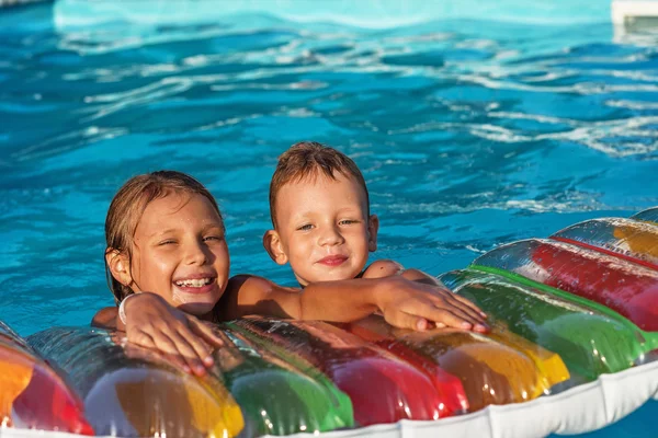 スイミングプールの青い水で遊ぶ幸せな子供たち. — ストック写真