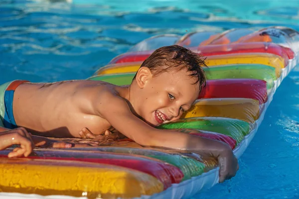 スイミング プールの青い水で遊んで喜んでいる子供. — ストック写真