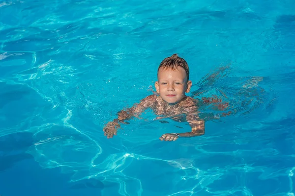 Šťastné dětství v modré vodě bazénu. — Stock fotografie