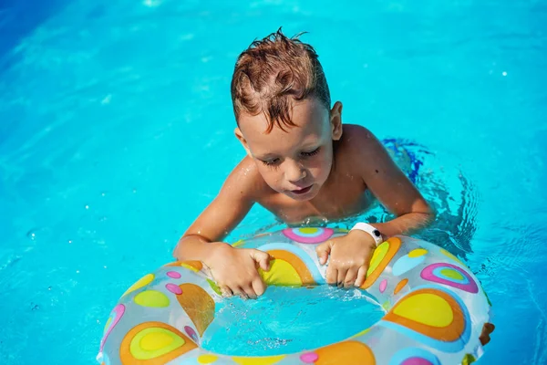 Ragazzo felice che gioca in acqua azzurra di piscina . — Foto Stock