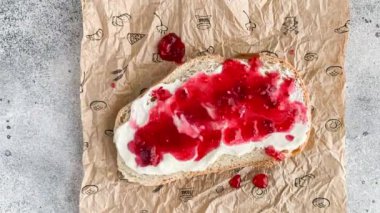 Beyaz ekmekli sandviç, ricotta peyniri, ahududu reçeli, amaranth puf şeker ve taze nane. Sağlıklı yaşam tarzı gıda konsepti. Hareket animasyonunu durdur, üst görünüm