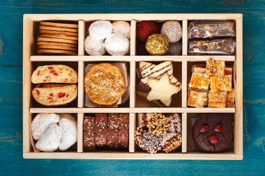 Noel kurabiyesi bisküvileri çeşitleri. Tatil Kurabiyesi Kutusu. Tahta kutuda çeşitli ev yapımı Noel kurabiyeleri. Büyük tahta bir kutuda tatlı bisküviler. Noel tatlı masası. Hediye fikri.