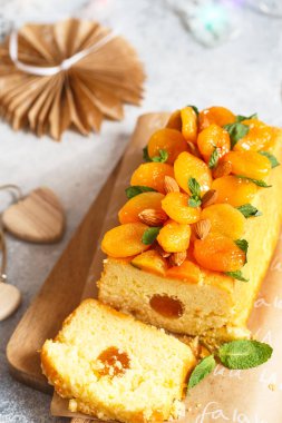 Taze sıkılmış portakal suyu ve kurutulmuş kayısı, nane yaprağı ve bademle süslenmiş aromalı turuncu kek..