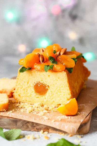 Orange Pound Cake flavored with freshly squeezed orange juice and zest decorated with dried apricots, mint leaves and almonds.