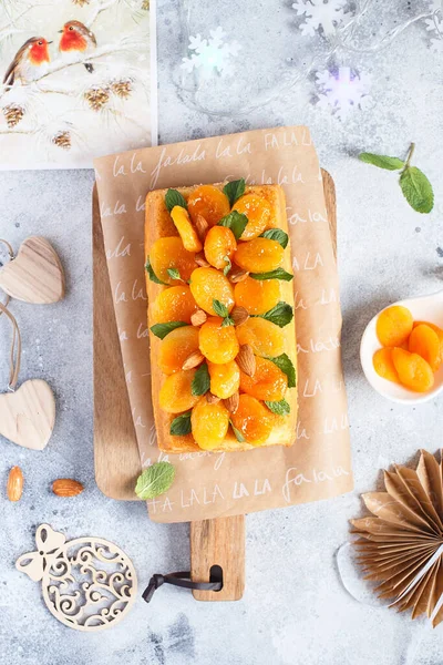 Orange Pound Cake flavored with freshly squeezed orange juice and zest decorated with dried apricots, mint leaves and almonds.