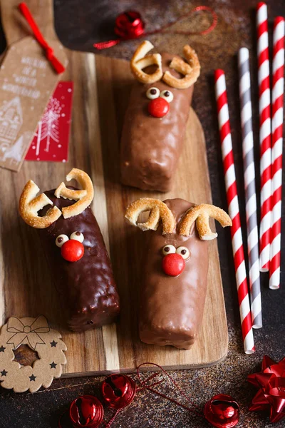 Reindeer cookies with candy red nose. Christmas concept. Cakes with a Christmas deer face with a red nose. Christmas baking. Preparations for the holiday.