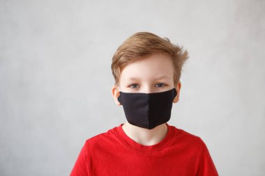 Corona virüsü 2019-NCov 'a karşı maske takan küçük bir çocuk. Corona virüsü ve grip salgını sırasında sargı bezi ya da solunum cihazı takmış bir çocuk. Tıbbi maskeli bir çocuk. Coronavirus karantinası.