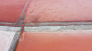 Pembe suyu olan güzel tuz gölünün havadan görünüşü. Uçan İHA 'dan pembe göl manzarası. Yukarıdan drone helikopter fotoğrafçılığı. İnsansız hava aracıyla manzara