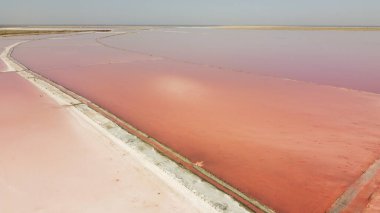 Pembe suyu olan güzel tuz gölünün havadan görünüşü. Uçan İHA 'dan pembe göl manzarası. Yukarıdan drone helikopter fotoğrafçılığı. İnsansız hava aracıyla manzara
