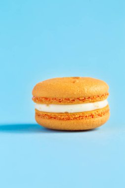 turuncu pasta ya da mavi arka planda badem kurabiyesi. Renkli bademli kurabiyeler. Fransız kurabiyeli keki yakın plan. Renkli arkaplanda makarnalar