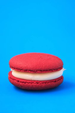 Kırmızı pasta ya da mavi arka planda badem kurabiyesi. Renkli bademli kurabiyeler. Fransız kurabiyeli keki yakın plan. Renkli arkaplanda makarnalar