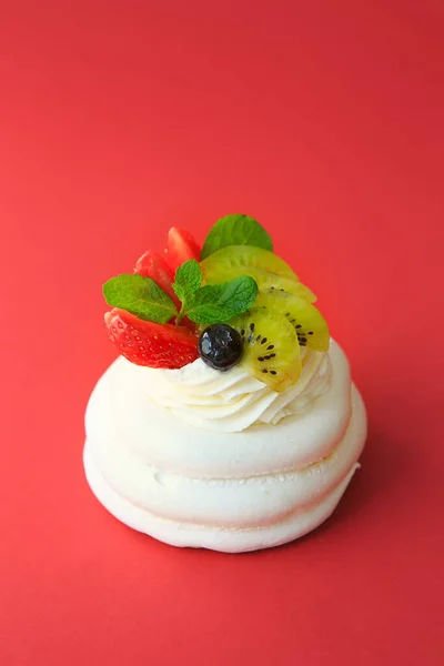 Mini Pavlova Cake meringue dessert with crisp crust and soft inside. Meringue dessert Pavlova cake with fresh strawberries, kiwi and mint. Summer dessert. French cake. Confectionery. Classic dessert