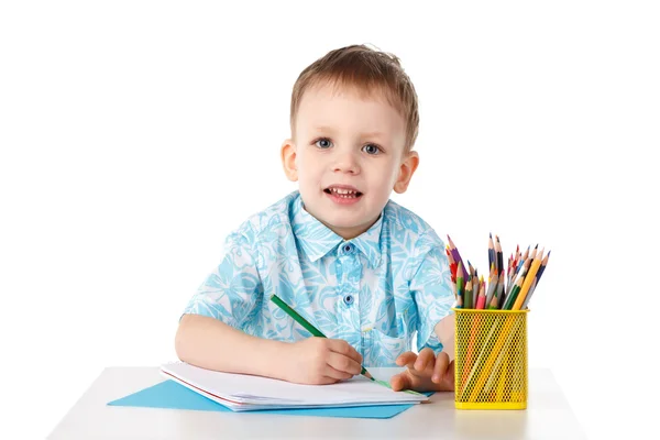 Uśmiechający się mały chłopiec rysuje kredkami — Zdjęcie stockowe