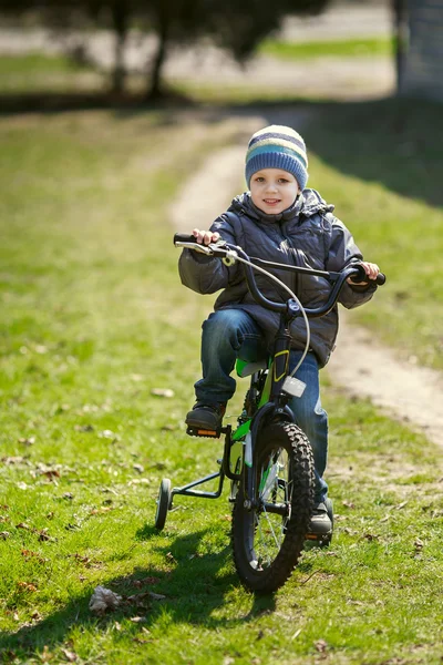 Niño pequeño montando una bicicleta en el parque — Foto de Stock