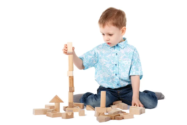 Menino brincando com designer de madeira no chão — Fotografia de Stock