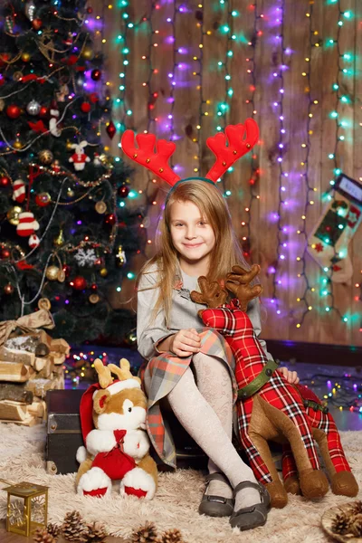 Niña esperando un milagro en las decoraciones navideñas — Foto de Stock