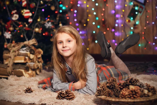 Niña esperando un milagro en las decoraciones navideñas — Foto de Stock