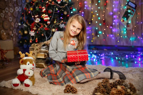 Niña esperando un milagro en las decoraciones navideñas — Foto de Stock