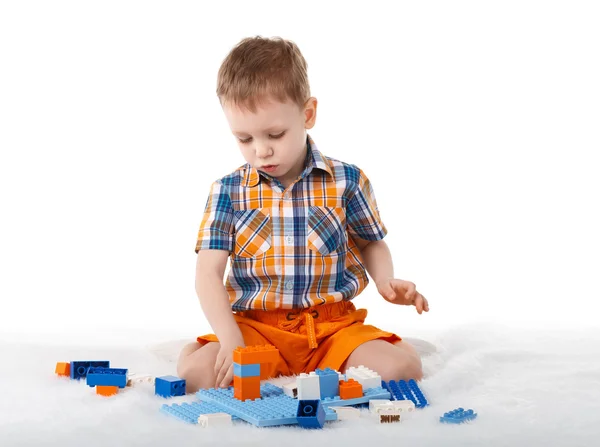 Kleine jongen spelen met designer op de vloer op witte pagina — Stockfoto