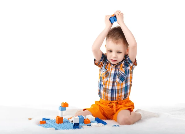 Kleiner Junge spielt mit Designer auf dem Fußboden isoliert auf Weiß — Stockfoto