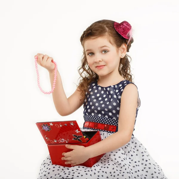 Маленька дівчинка захоплюється аксесуарами в коробці — стокове фото