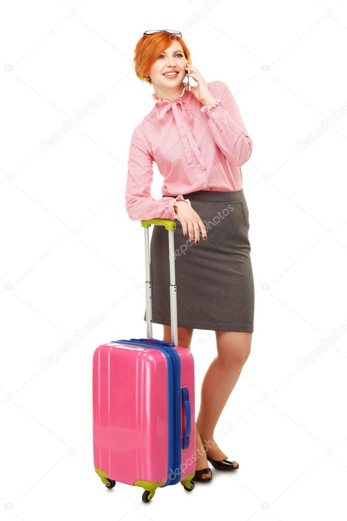 Business woman in business trip with a suitcase on wheels speaki